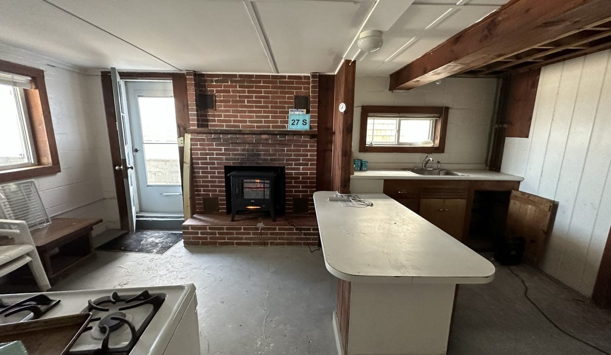 a kitchen with a fireplace and a stove top oven.