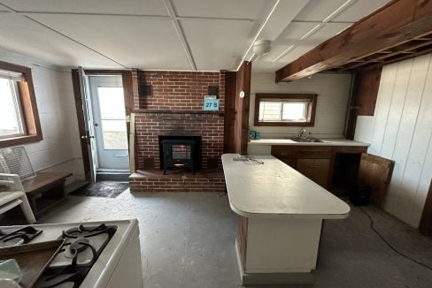 a kitchen with a fireplace and a stove top oven.