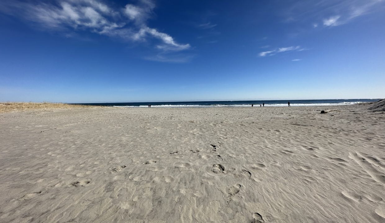 a sandy beach with footprints in the sand.
