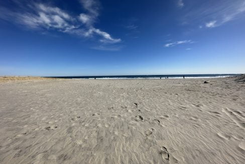 a sandy beach with footprints in the sand.