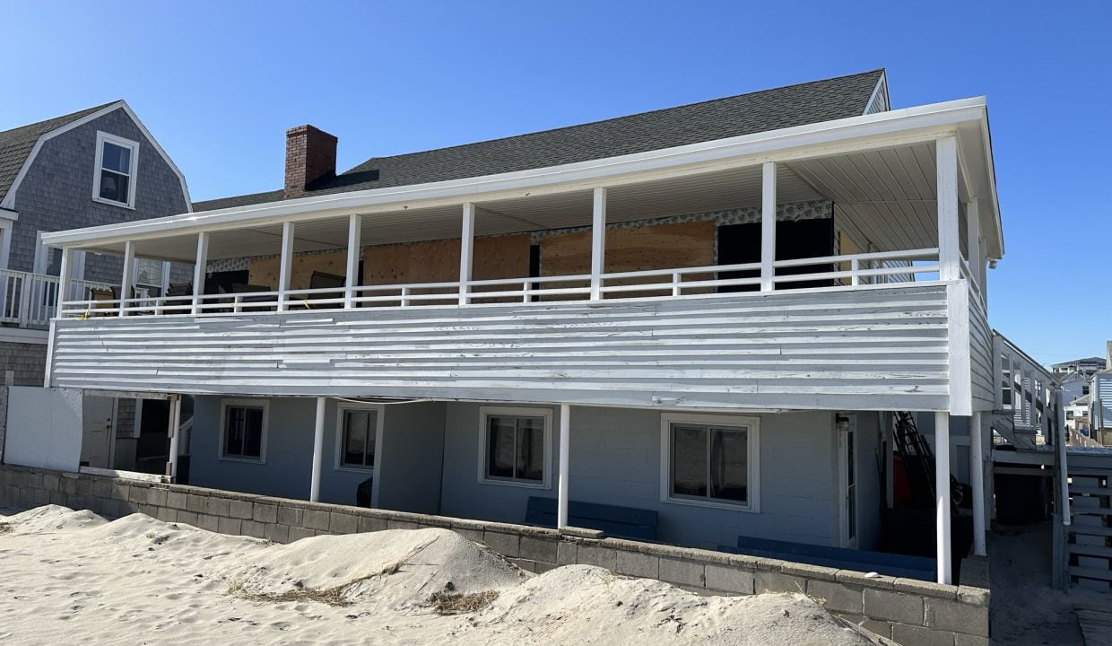 a beach house with a balcony and a deck.