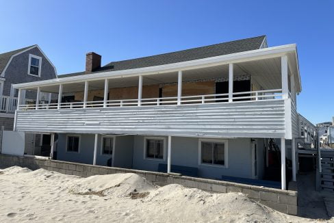 a beach house with a balcony and a deck.