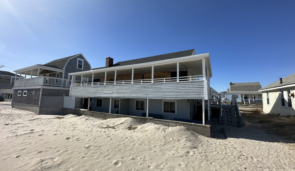 a house on the beach with a balcony.