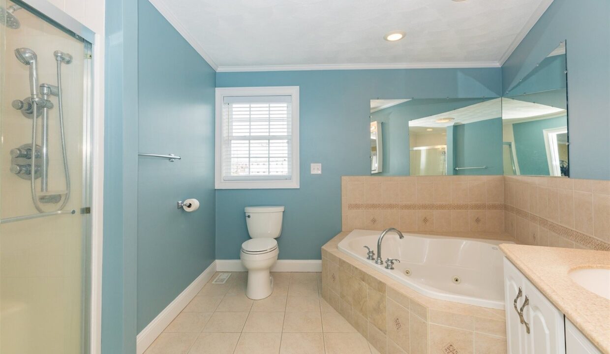 a bathroom with a tub, toilet and sink.