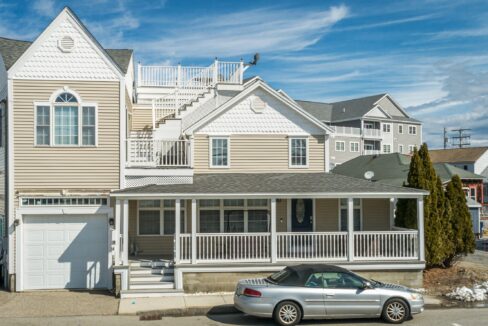 a car parked in front of a two story house.