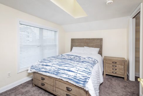 a bed sitting in a bedroom next to a window.