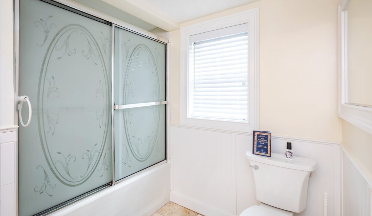 a bathroom with a toilet and a glass shower door.