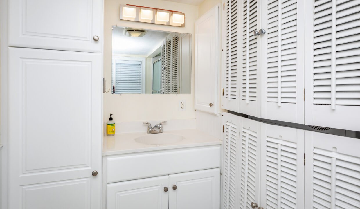 a bathroom with white cabinets and a sink.