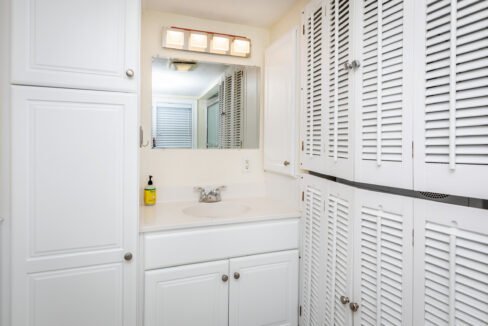 a bathroom with white cabinets and a sink.