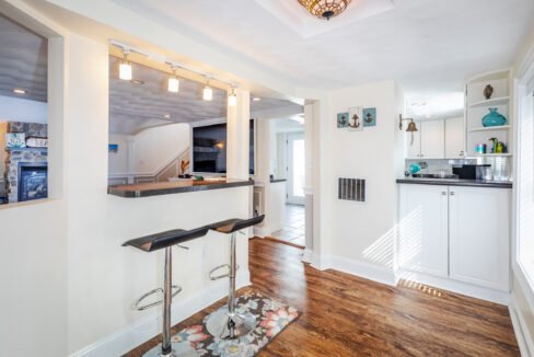 a white kitchen with a bar and stools.