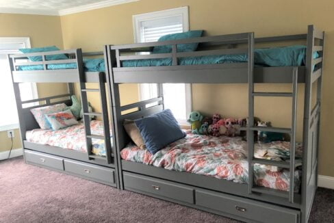 a room with three bunk beds and a stuffed animal.