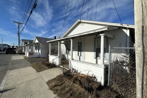 a small white house sitting next to a street.