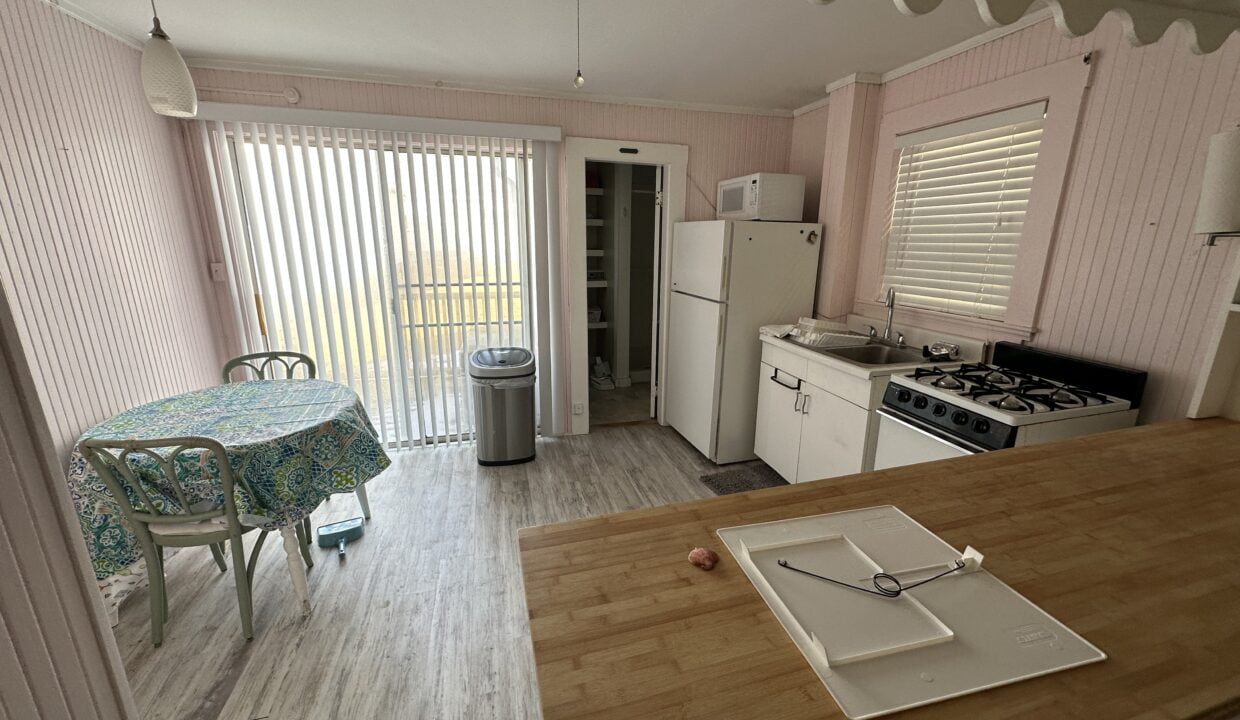 a kitchen with a table a stove and a refrigerator.