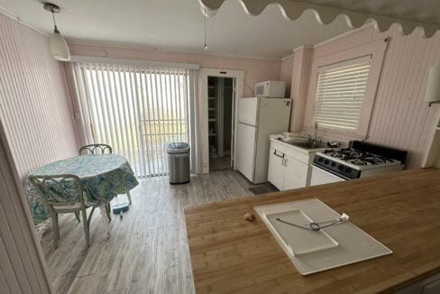 a kitchen with a table a stove and a refrigerator.