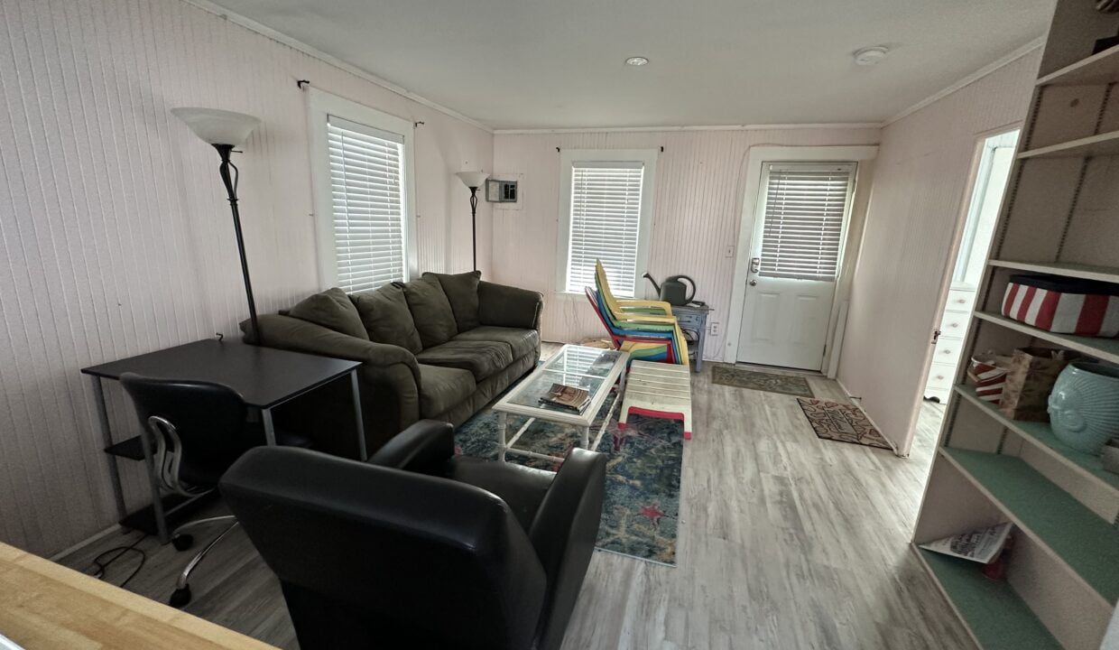 a living room filled with furniture and a wooden floor.