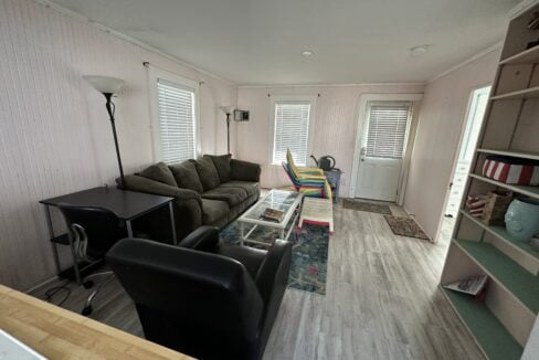 a living room filled with furniture and a wooden floor.