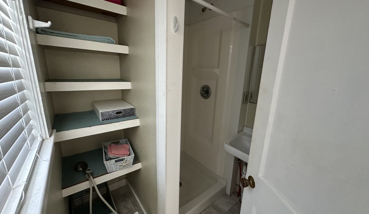 a walk in shower sitting next to a white door.