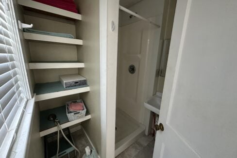 a walk in shower sitting next to a white door.