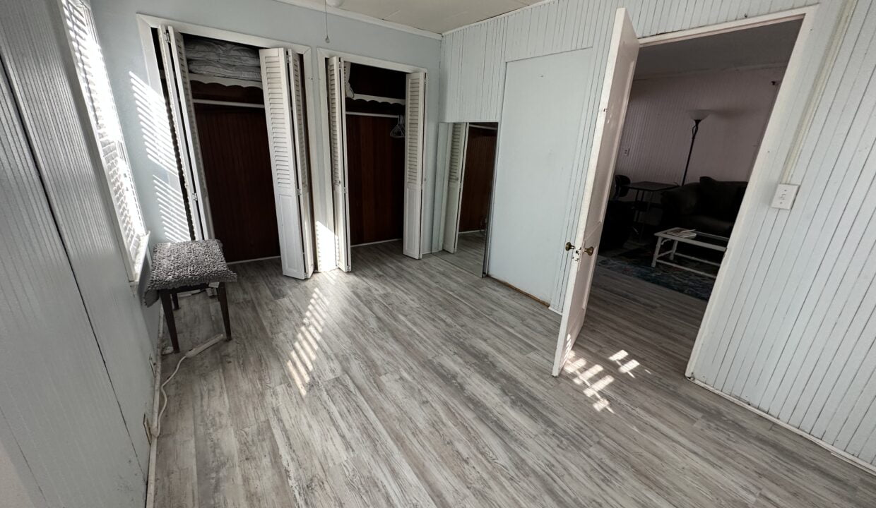 an empty room with white walls and wooden floors.