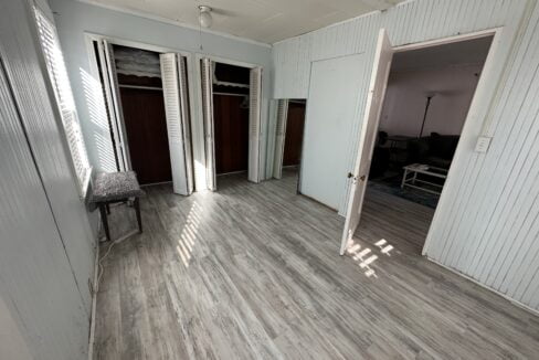 an empty room with white walls and wooden floors.