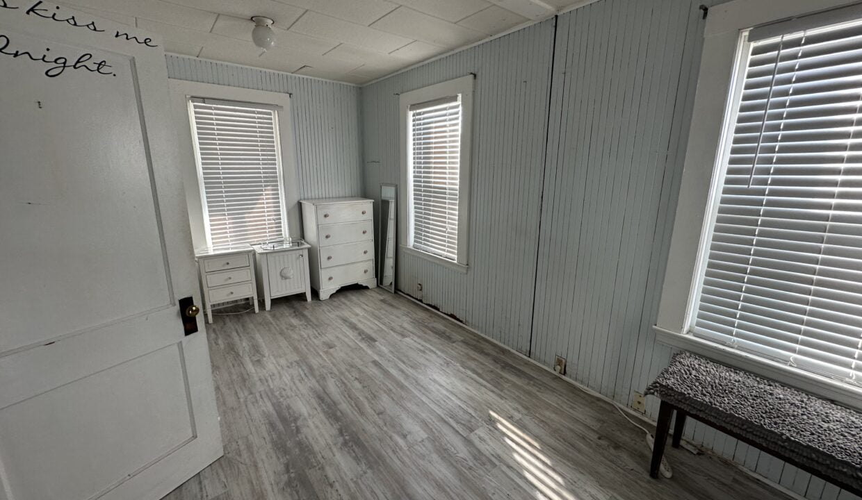 a room with a bench and two windows.