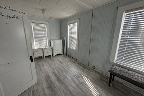 a room with a bench and two windows.
