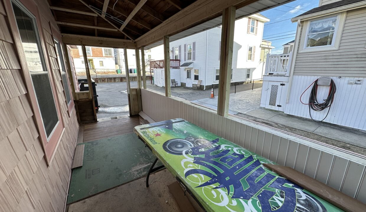 a wooden bench sitting on the side of a building.