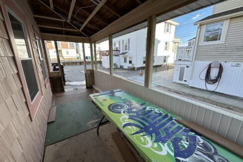 a wooden bench sitting on the side of a building.