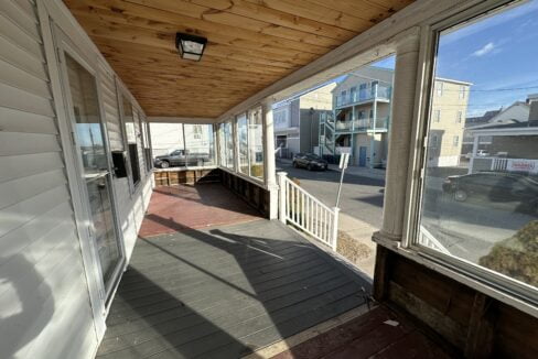 a porch with a wooden ceiling and a light fixture.