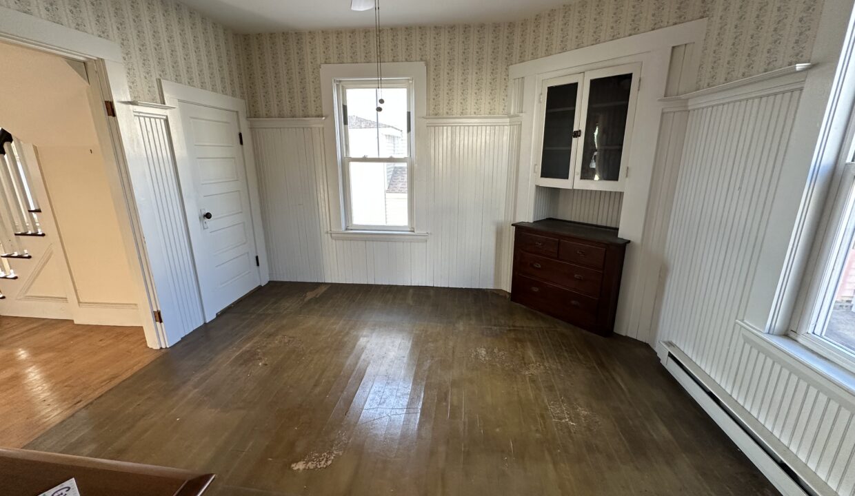 an empty room with a ceiling fan and hard wood floors.