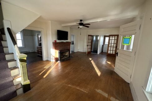 a living room with hard wood floors and a ceiling fan.