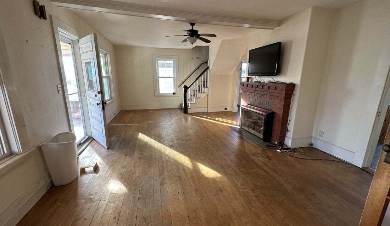 a living room with hard wood floors and a fireplace.
