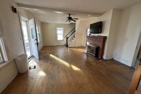 a living room with hard wood floors and a fireplace.