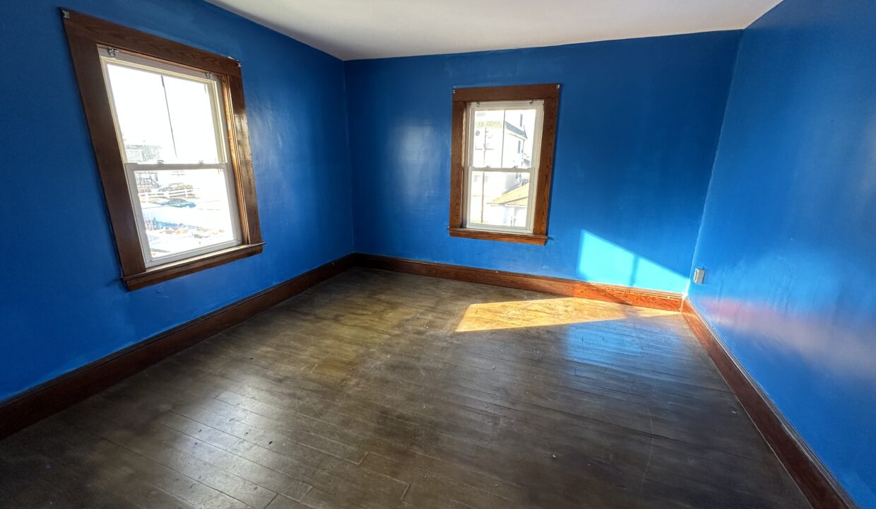 a empty room with blue walls and wooden floors.