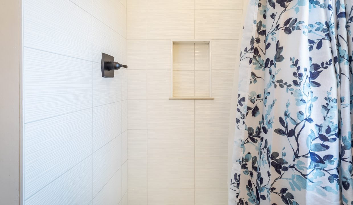 a blue and white shower curtain is hanging in a bathroom.