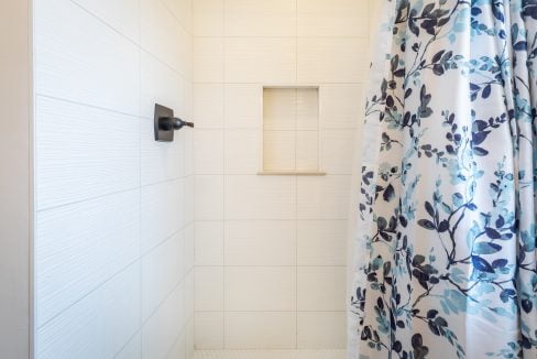 a blue and white shower curtain is hanging in a bathroom.