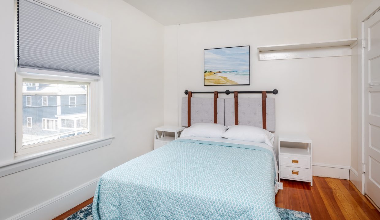 a small bedroom with a bed and a window.