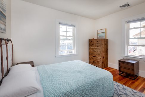 a bedroom with hardwood floors and a blue comforter.