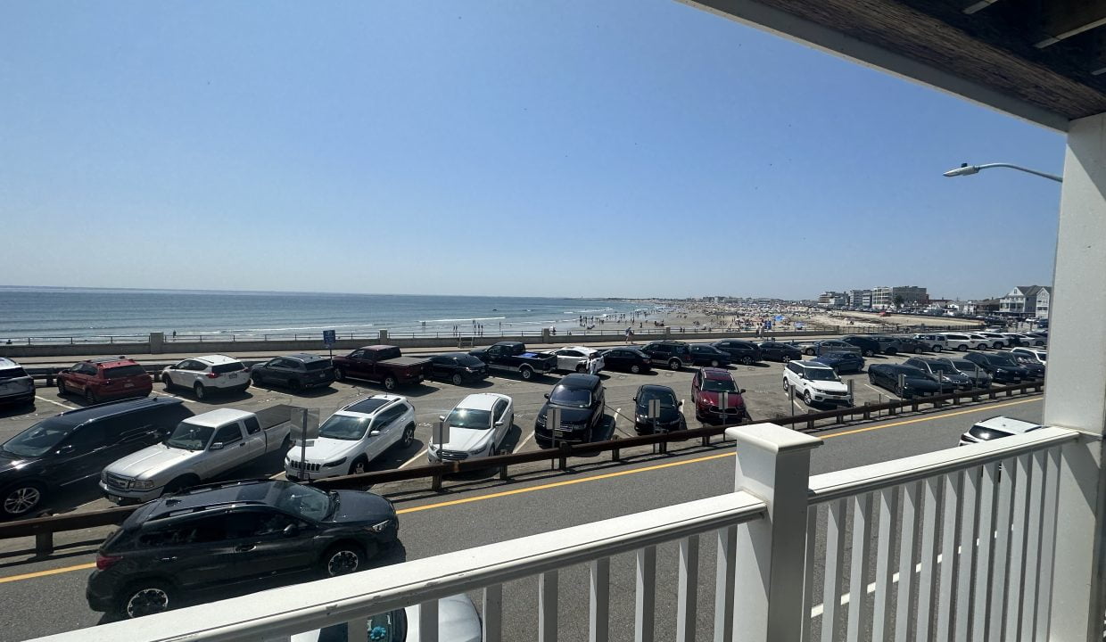a parking lot with cars and a beach.