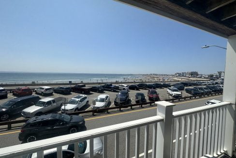 a parking lot with cars and a beach.