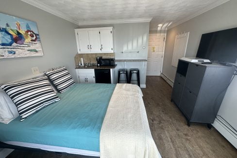 a bed sitting in a bedroom next to a refrigerator.