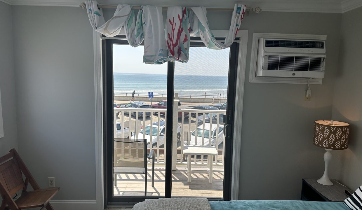 a bedroom with a balcony overlooking the ocean.