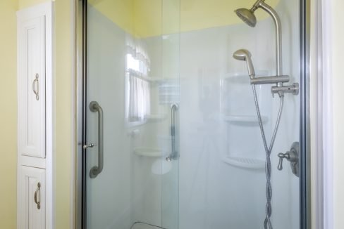 a shower with a glass door and a shower head.