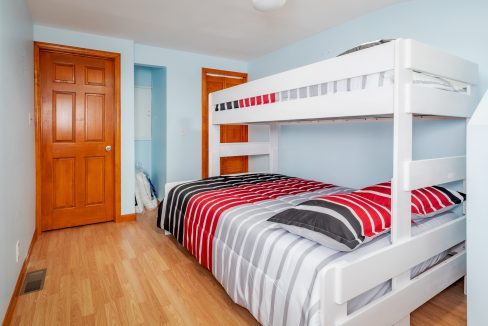 a white bunk bed sitting in a bedroom next to a wooden door.