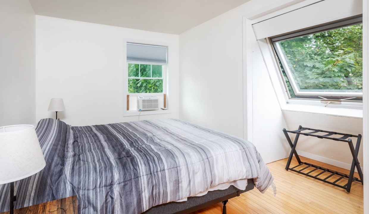 A bedroom with a bed and a window.