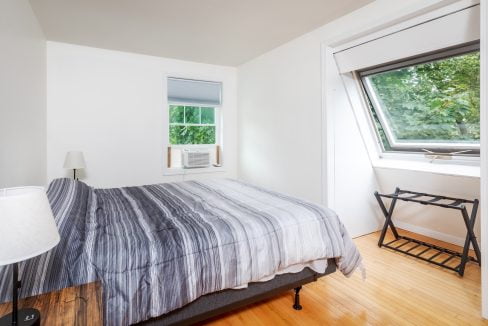 A bedroom with a bed and a window.