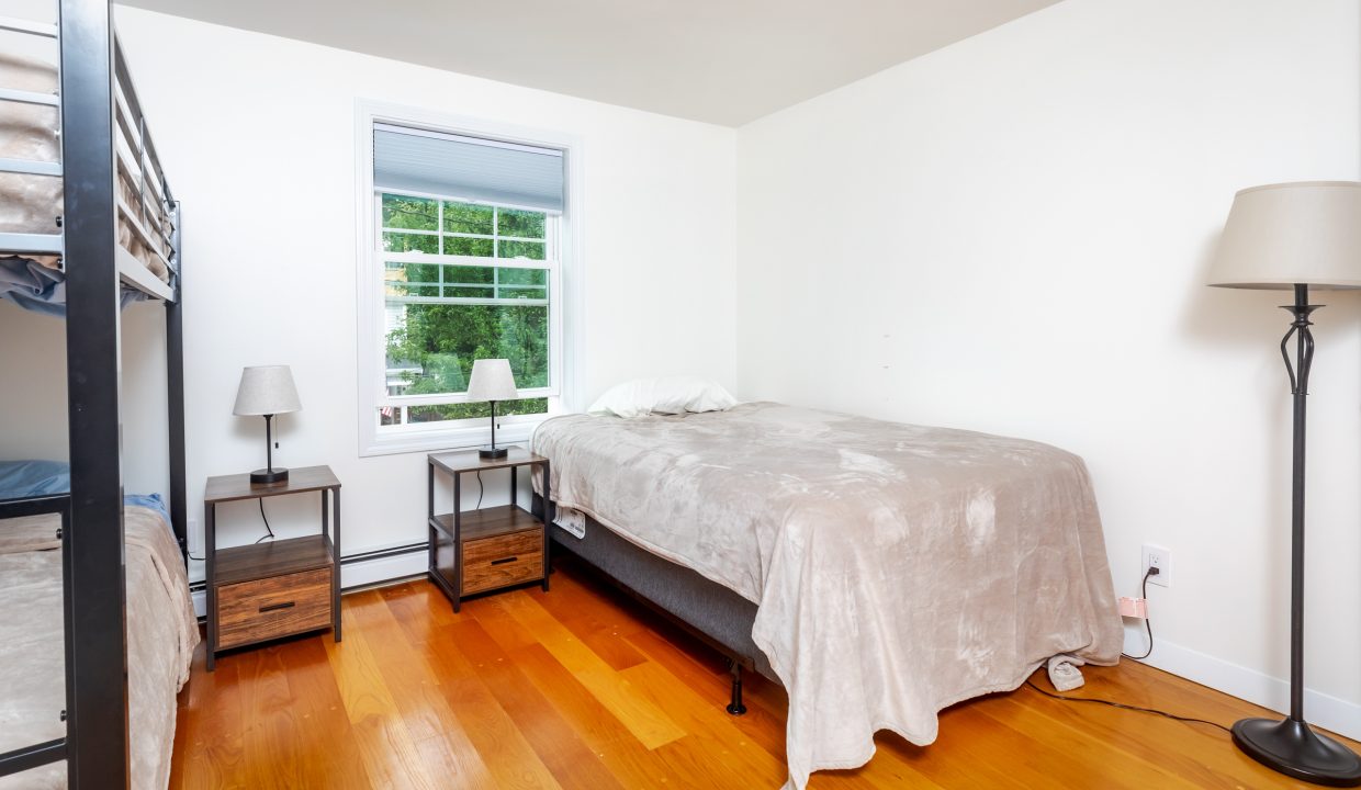 A small bedroom with two bunk beds and a window.