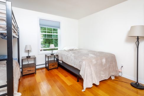 A small bedroom with two bunk beds and a window.