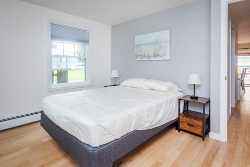 A bedroom with hardwood floors and a bed.