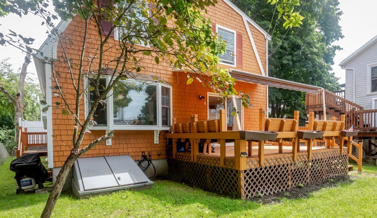 An orange house with a deck in the backyard.